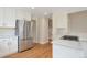 Modern kitchen with stainless steel refrigerator, granite countertops, and hardwood floors next to the staircase at 20271 E Lake Ave, Centennial, CO 80016