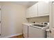 Laundry area with full size washer and dryer and white cabinets at 20271 E Lake Ave, Centennial, CO 80016