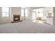 Bright and airy living room featuring a brick fireplace, windows, and seamless transition to a dining/kitchen area at 20271 E Lake Ave, Centennial, CO 80016