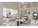 Staged open-concept living room features a soaring ceiling, staircase, and adjacent kitchen with barstool seating at 20271 E Lake Ave, Centennial, CO 80016