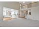 Open-concept living room boasts a soaring ceiling, staircase with wooden railing, and an adjacent kitchen area at 20271 E Lake Ave, Centennial, CO 80016