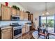 Kitchen open to the dining area with stainless gas range and views of the backyard at 5350 Clearbrooke Ct, Castle Rock, CO 80104