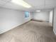 Spacious finished basement featuring neutral carpet, white walls, and natural light from a window at 10707 Milliken St, Parker, CO 80134