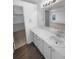 Bright bathroom featuring a large mirror, wood-look flooring, and a walk-in closet for extra storage at 10707 Milliken St, Parker, CO 80134