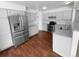Kitchen with stainless steel appliances, granite countertops, white cabinets, and hardwood floors at 10707 Milliken St, Parker, CO 80134