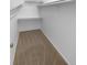 This carpeted walk-in closet has ample storage and shelving with a single light source at 10707 Milliken St, Parker, CO 80134