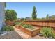 Landscaped backyard featuring a wooden fence, lush greenery, and two raised garden beds at 15437 W 95Th Ave, Arvada, CO 80007