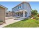 Backyard view from the grassy area showing a patio with string lights and a fire pit at 15437 W 95Th Ave, Arvada, CO 80007