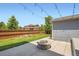 Well maintained backyard with a fire pit, lawn, garden beds, and wooden fence creating a private outdoor oasis at 15437 W 95Th Ave, Arvada, CO 80007