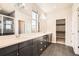 Modern bathroom with double sinks, sleek cabinets, tile flooring, walk-in closet, and a luxurious shower at 15437 W 95Th Ave, Arvada, CO 80007
