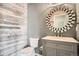 Modern bathroom with gray vanity, decorative mirror, and wood accent wall paneling at 15437 W 95Th Ave, Arvada, CO 80007