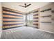 Inviting bedroom showcases a striking wood accent wall, built-in shelves, and two windows at 15437 W 95Th Ave, Arvada, CO 80007