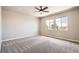 Bright bedroom features a ceiling fan, neutral walls, and plush carpeting and two large windows at 15437 W 95Th Ave, Arvada, CO 80007