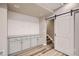 Bonus room with sleek cabinets, granite counters, shiplap wall, and sliding barn door at 15437 W 95Th Ave, Arvada, CO 80007