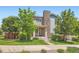 Charming two-story home featuring stone accents, a well-manicured lawn, and lush greenery at 15437 W 95Th Ave, Arvada, CO 80007