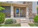 Inviting front porch with stone accents and a decorative front door at 15437 W 95Th Ave, Arvada, CO 80007