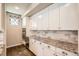 Gourmet kitchen featuring white cabinets, granite countertops, and stainless steel built-in microwave at 15437 W 95Th Ave, Arvada, CO 80007