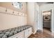 Inviting mudroom with bench seating, storage cabinets, and decorative wall hooks at 15437 W 95Th Ave, Arvada, CO 80007