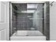 Modern bathroom with dark tiled walls and a glass shower door at 3050 W 107Th Pl # E, Westminster, CO 80031