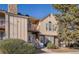 Charming two-story townhouse with a balcony and a stone chimney, surrounded by mature trees and landscaping at 3050 W 107Th Pl # E, Westminster, CO 80031