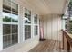 Inviting covered porch area with wood flooring, large windows, and a decorative welcome sign at 3050 W 107Th Pl # E, Westminster, CO 80031