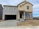 Two-story home featuring stone accents, an attached two-car garage, and a concrete driveway at 15295 Fillmore St, Thornton, CO 80602