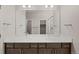 Bright bathroom showcasing a double sink vanity with a large mirror and modern lighting at 21044 E 63Rd Dr, Aurora, CO 80019