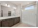 Bright bathroom featuring a double sink vanity with a glass-enclosed shower and subway tile at 21044 E 63Rd Dr, Aurora, CO 80019