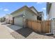 Exterior view of the home, featuring an attached garage, fence, and concrete driveway at 21044 E 63Rd Dr, Aurora, CO 80019