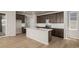 This modern kitchen with a central island has stainless steel appliances and lots of cabinet space at 21044 E 63Rd Dr, Aurora, CO 80019