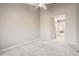 An airy bedroom featuring neutral walls, plush carpet, ceiling fan, and a well lit hall at 7373 E Iowa Ave # 1112, Denver, CO 80231