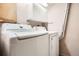 Functional laundry room features modern washing machine and dryer with overhead storage at 7373 E Iowa Ave # 1112, Denver, CO 80231