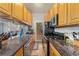 Cozy kitchen featuring stone countertops, wood cabinets, and stainless steel appliances at 1640 N Downing St # 103, Denver, CO 80218