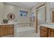 Bright bathroom with a vanity, tub, tiled walls, and elegant fixtures at 30 Eagle Dr, Littleton, CO 80123