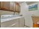 Laundry room with a side-by-side washer and dryer and wood cabinets at 30 Eagle Dr, Littleton, CO 80123