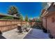 Backyard patio showcasing an outdoor dining set surrounded by lush landscaping and wooden fence at 30 Eagle Dr, Littleton, CO 80123