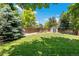 Large, well-maintained backyard with a privacy fence, mature trees, shed, and garden area, perfect for outdoor activities at 4393 E Andover Ave, Castle Rock, CO 80104
