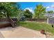 Beautiful backyard with a concrete patio, wooden deck with stairs, and a lush green lawn surrounded by mature trees at 4393 E Andover Ave, Castle Rock, CO 80104