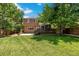 Spacious backyard with lush lawn, deck, concrete patio, and privacy fence; perfect for outdoor living and entertaining at 4393 E Andover Ave, Castle Rock, CO 80104