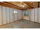 Unfinished basement area with exposed framing, windows, and concrete flooring at 4393 E Andover Ave, Castle Rock, CO 80104
