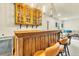 Charming basement bar area with wooden cabinets, pendant lighting, and adjacent seating at 2594 Scoter Ln, Castle Rock, CO 80104