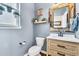 Charming powder room with wood-look vanity, stylish mirror, and modern fixtures at 2594 Scoter Ln, Castle Rock, CO 80104