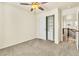 This carpeted bedroom features a ceiling fan, closet with sliding doors, and a light-filled view to the hall at 2594 Scoter Ln, Castle Rock, CO 80104