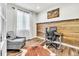 Bright home office featuring a wood accent wall, hardwood floors, and a comfortable chair at 2594 Scoter Ln, Castle Rock, CO 80104