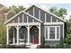 Charming home featuring a covered porch, a gray exterior, white trim, and a red front door at 30 Waterford St, Erie, CO 80516