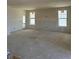 Bright living room under construction with drywall, large windows, and an exterior door at 30 Waterford St, Erie, CO 80516
