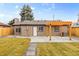 View of home's backyard showing grass and a concrete patio area at 3210 Magnolia St, Denver, CO 80207