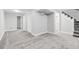 Finished basement space with neutral carpet, white walls, and access to additional rooms and stairs at 3210 Magnolia St, Denver, CO 80207