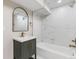 Modern bathroom featuring white marble tile, sleek vanity with gold hardware, and a bathtub with shower at 3210 Magnolia St, Denver, CO 80207
