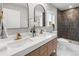 Bathroom featuring a double sink, stunning mirrors, and a tiled shower with sleek modern fixtures at 3210 Magnolia St, Denver, CO 80207